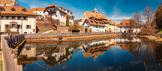 High resolution stitched alpine spring panorama with reflections in a pond near Klobenstein,...