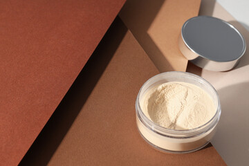 A bottle of powder, light shade, on a beige background.