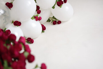Garland of white balloons and burgundy roses.