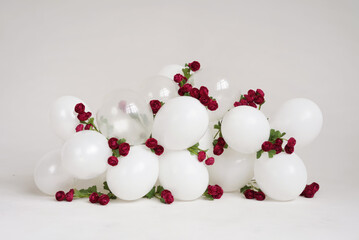 Garland of white balloons and burgundy roses.