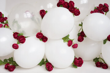 Garland of white balloons and burgundy roses.