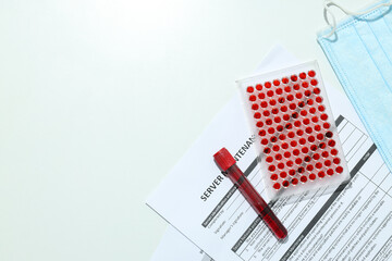 Test tube with blood, document and medical mask on white background, space for text