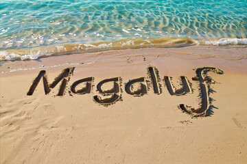 Magaluf, Spain written in the sand on a beach. Spanish tourism and vacation background
