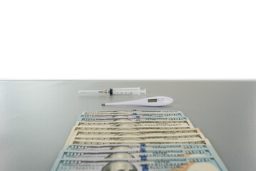 lying dollars syringe and thermometer on gray table with copy space background