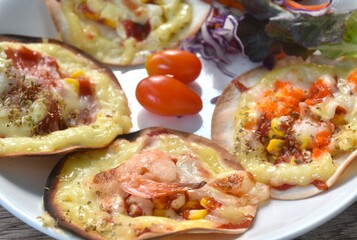 mini homemade pizza topping sausage and cheese with salad on plate