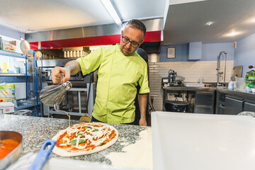 applying the last ingredients to pizza, working in the restaurant kitchen. High quality photo