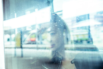 Woman traveler contemplating outdoor view from window of train. Young lady on commute travel to...