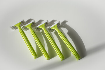Green disposable shaving razors on white background