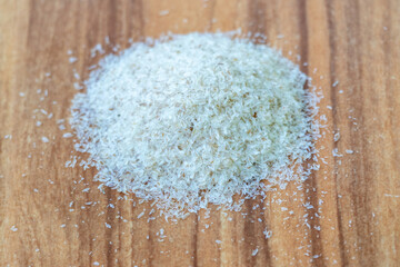 Psyllium husk isolated on wooden background. It's a common home remedy for constipation and other...
