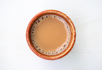 A cup of Milk tea or Dudh Cha in a traditional natural clay cup. Top view