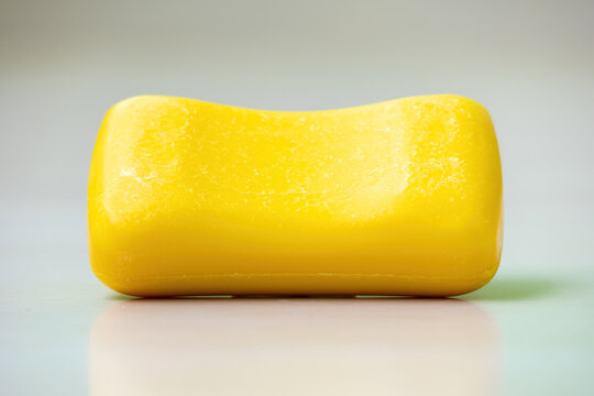 A yellow soap bar on a white background