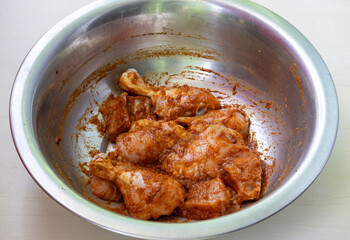 Marinated chicken with spice in a steel bowl before cooking