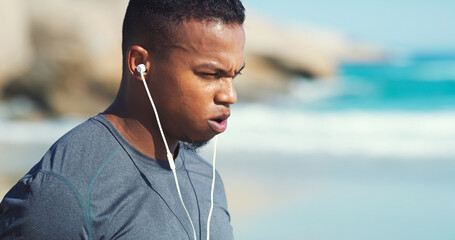 Fitness, headphones and black man with fatigue at beach to relax on audio, streaming and training....