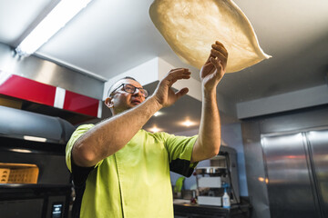 Pizza maker spinning dough in kitchen. High quality photo