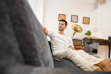 Handsome Stylish Man Drinking Coffee While Taking Break From Work In Home Office
