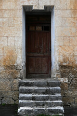 Fototapeta na wymiar Old locked wooden door in vintage wall, vertical picture
