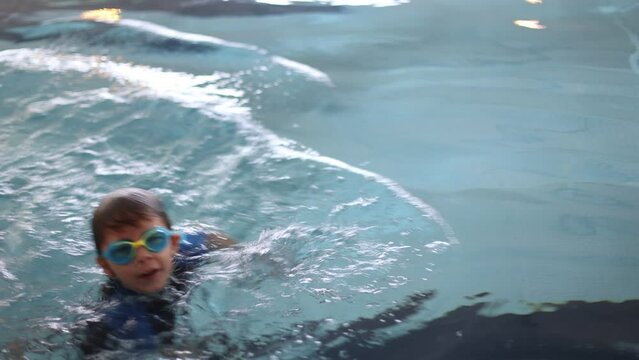 Cute preschool child, sweet boy, swimming in swimming pool