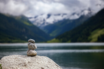 Cairn with Gerlos Reservoir and Alpine Mountains in Background