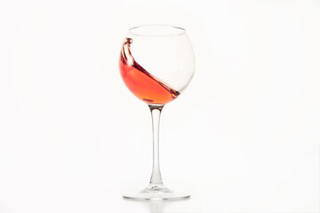 Diagonal wave of rose wine, alcohol is in glass on white isolated.