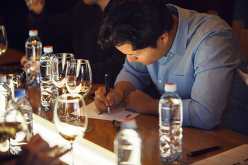 Sommelier Meticulously Evaluating Wine During an Indoor Tasting Event