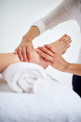 Foot, hands and masseuse with massage at spa for treatment, beauty and skincare at luxury resort with wellness. Pedicure, cosmetics and people for physical therapy, healing for self care and relief