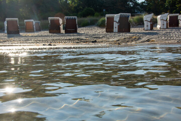 Water with a view of blurred beach chairs in the background