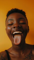 Smiley, tongue-out woman in studio with confidence feeling ridiculous. Orange backdrop, young portrait, African woman in fashionable, current, student attire with Gen Z radiance.
