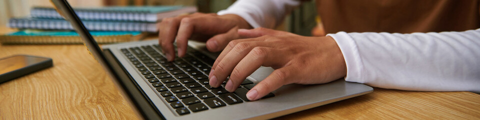 Web banner with hands of student coding on laptop