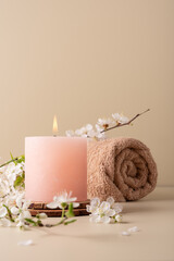 Burning candle and cherry blossom twig, spa still life