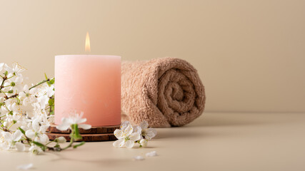 Burning candle and cherry blossom twig, spa still life
