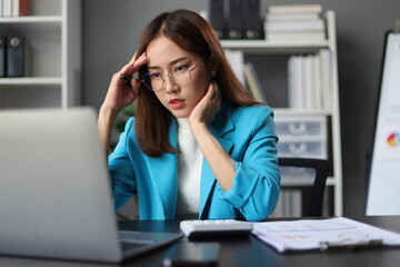 Businesswoman working with laptop in office, she is seriously working, is stressed and tired.