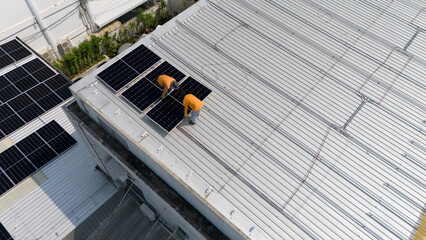 Aerial top view of a technician drone installing solar panels on the roof.