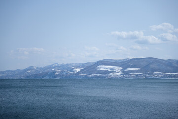 海と雪の積もった山 北海道