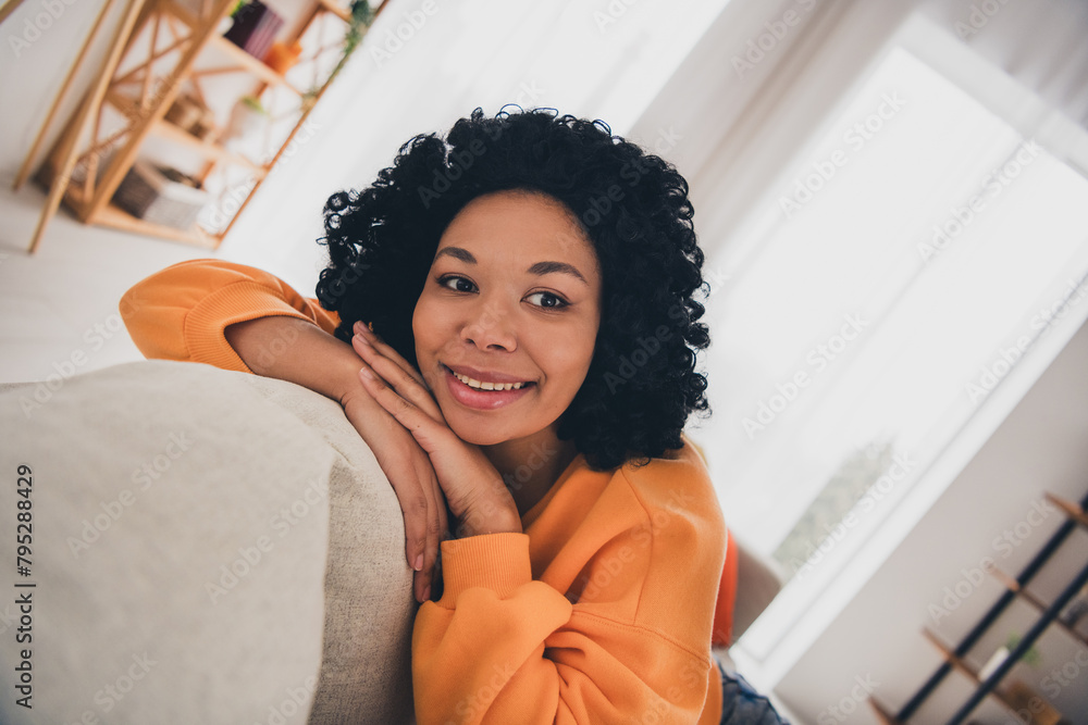 Wall mural Photo portrait of lovely young lady lean on sofa sleepy dressed casual orange clothes cozy day light home interior living room