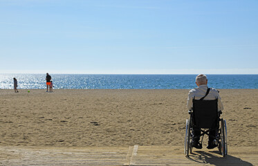 hombre mayor en silla de ruedas discapacitado minusválido  en una playa accesibilidad 4M0A8529-as24