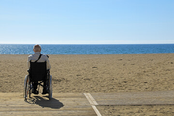 hombre mayor en silla de ruedas discapacitado minusválido  en una playa accesibilidad 4M0A8536-as24