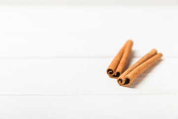 Cinnamon sticks on a textured wooden background. Cinnamon roll. Spicy spice for baking, desserts and drinks. Fragrant ground cinnamon. cinnamon powder Close-up. Place for text. copy space