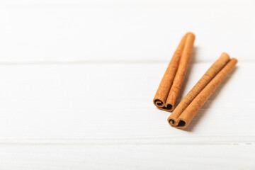 Cinnamon sticks on a textured wooden background. Cinnamon roll. Spicy spice for baking, desserts and drinks. Fragrant ground cinnamon. cinnamon powder Close-up. Place for text. copy space
