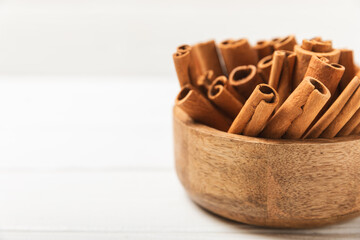 Cinnamon sticks on a textured wooden background. Cinnamon roll. Spicy spice for baking, desserts and drinks. Fragrant ground cinnamon. cinnamon powder Close-up. Place for text. copy space
