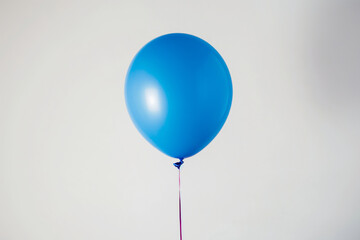 A single blue balloon with a red string against a plain white background.