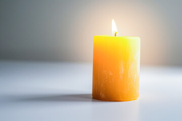 A single lit orange candle against a plain light background, emitting a soft glow.