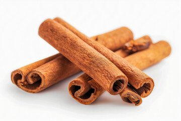 Close-up of several cinnamon sticks stacked on a white background, highlighting their texture and warm color.