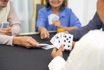 group of active senior pensioners playing cards game together, concept elderly retired people entertainment,recreation,encourages social interaction,help memory retention