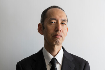 睨むスーツ姿の日本人の中年男性のポートレイト - obrazy, fototapety, plakaty