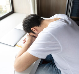 Tired and bored student sleeping on the desk while preparing for exams	