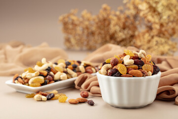 The mix of various nuts and raisins on a beige background.