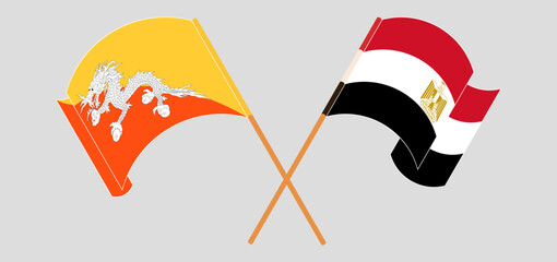 Crossed and waving flags of Bhutan and Egypt