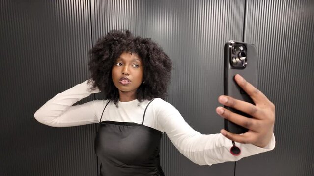 The series of images depicts a lively and expressive young African American black woman taking a selfie in an elevator. She confidently poses with her smartphone, experimenting with different angles