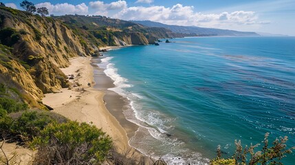 Obraz premium A picturesque coastal landscape with golden sands stretching along the shoreline and pristine waters shimmering in the sunlight, framed by lush vegetation and dramatic cliffs