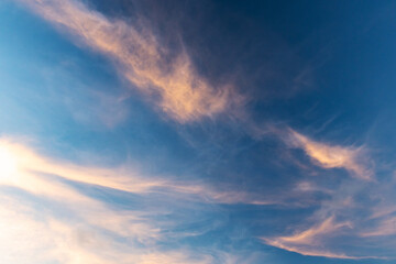 Colorful clouds are in deep blue evening sky, natural background